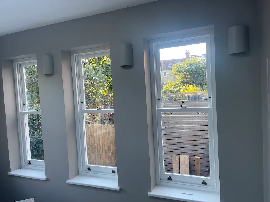 Three restored white sash windows in a modern grey living room