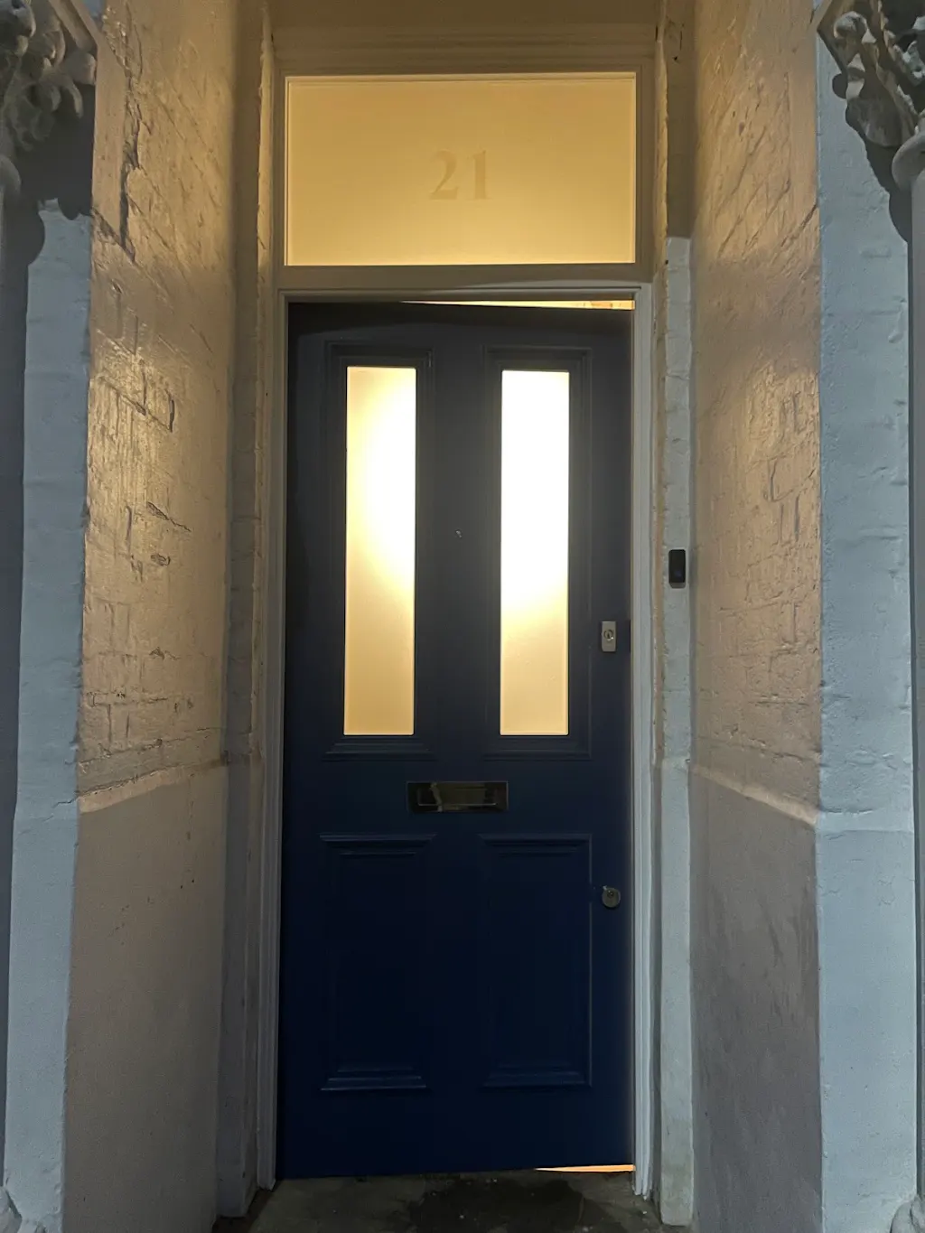 Navy blue front door with frosted glass panels and gold '21'