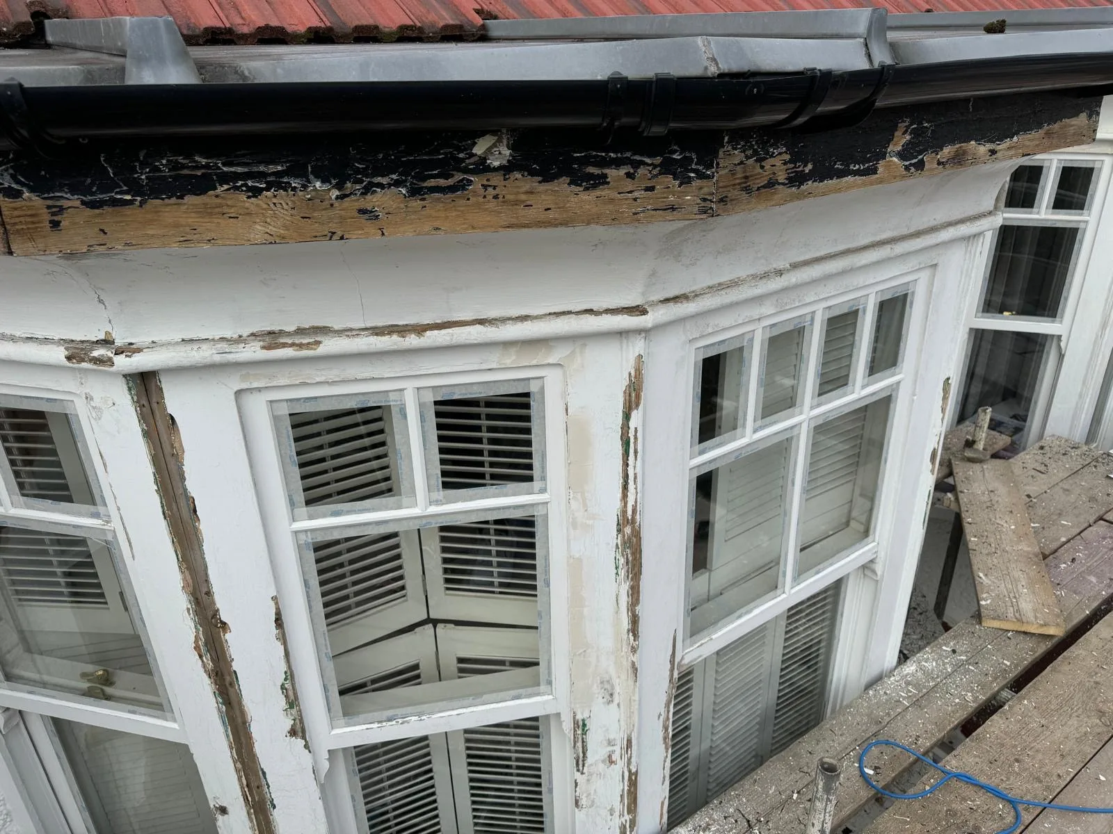 Rotten fascia and bay window frame stripped back to bare timber before repair