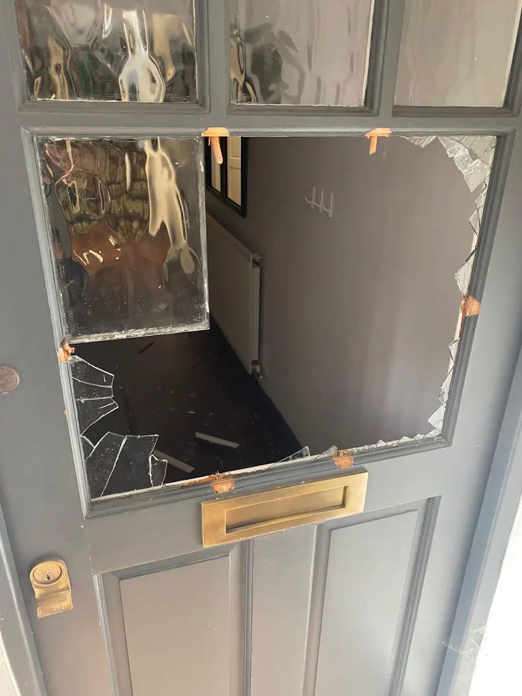 Smashed front door glass panel awaiting repair and repaint