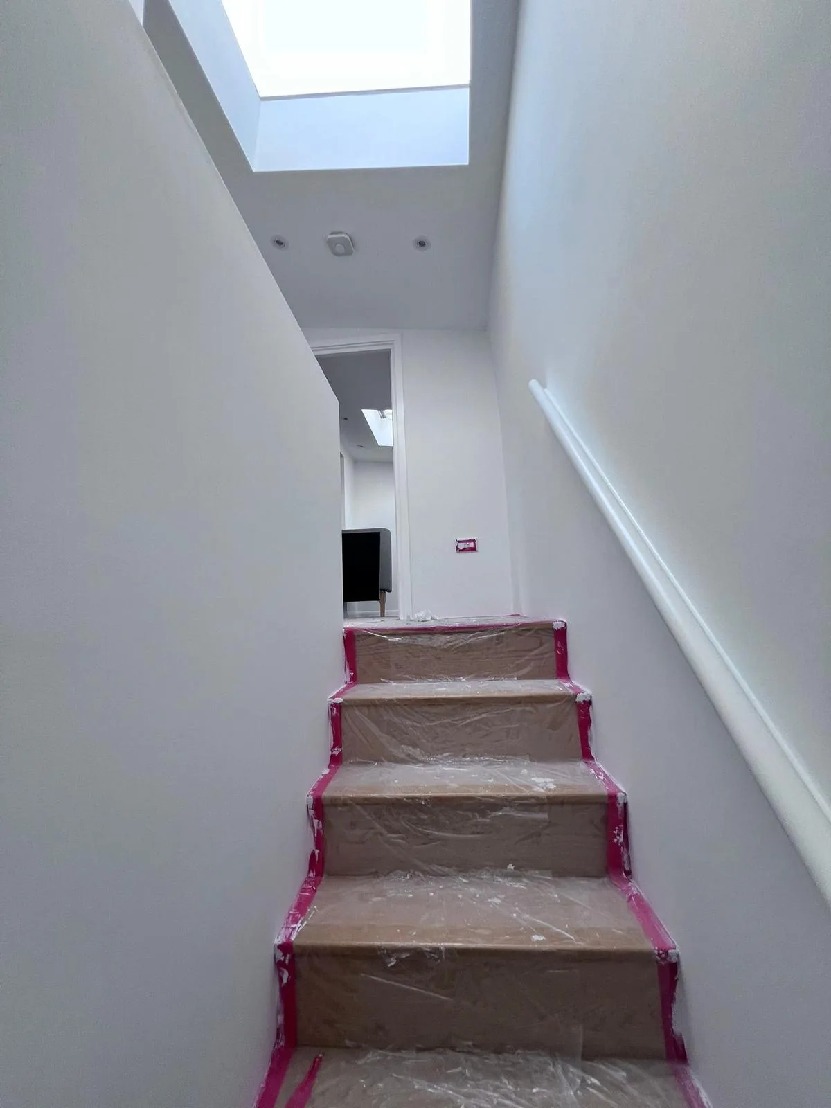 Loft staircase masked for painting with skylight and fresh white walls