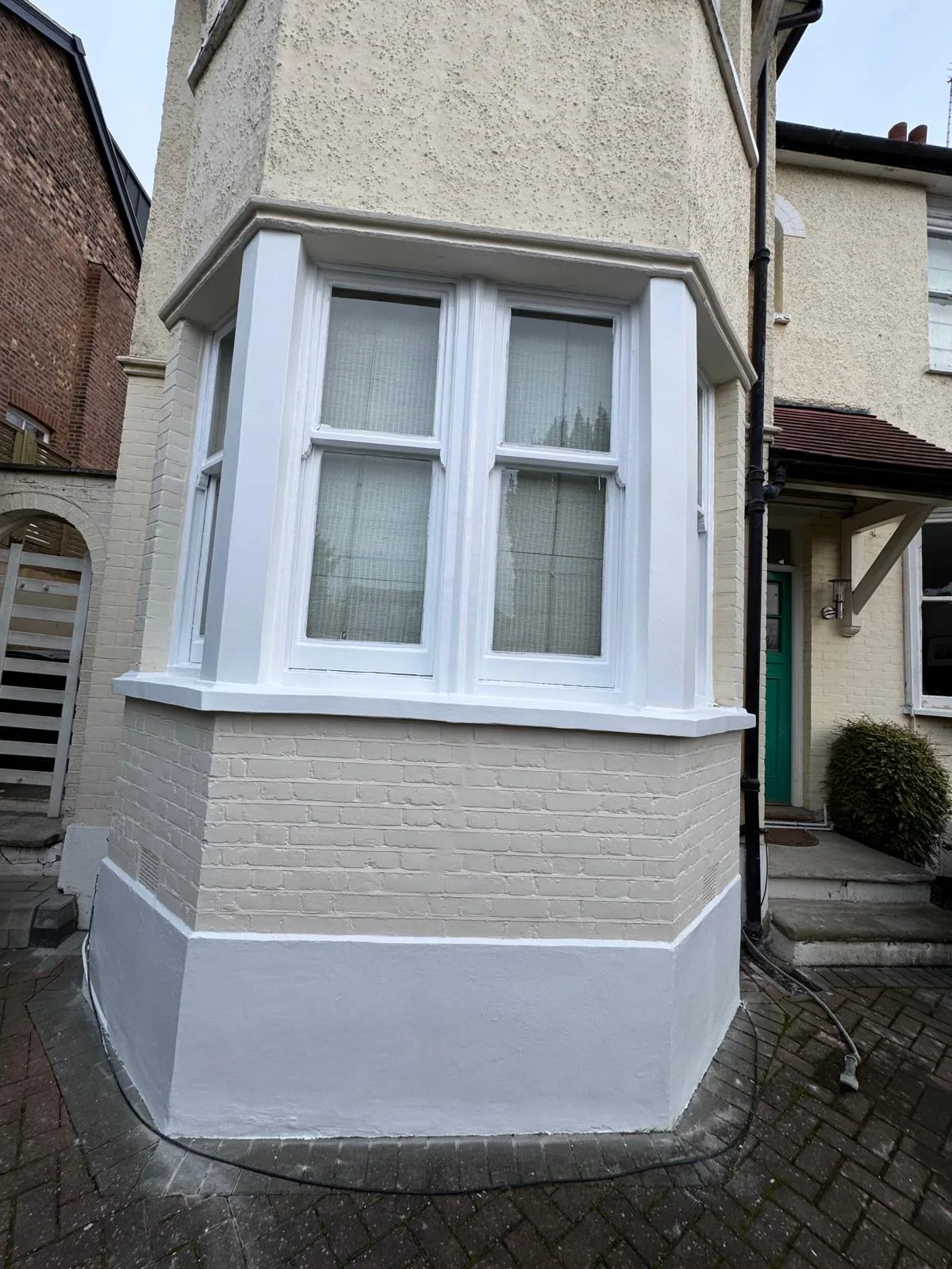 Freshly repainted white bay window on a period London home after restoration