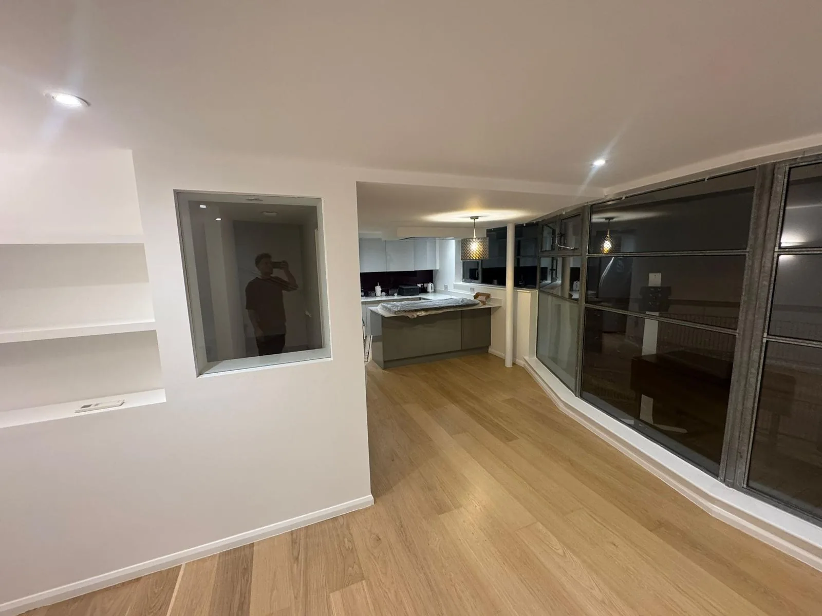 Open-plan lounge and kitchen repainted in warm white with oak flooring