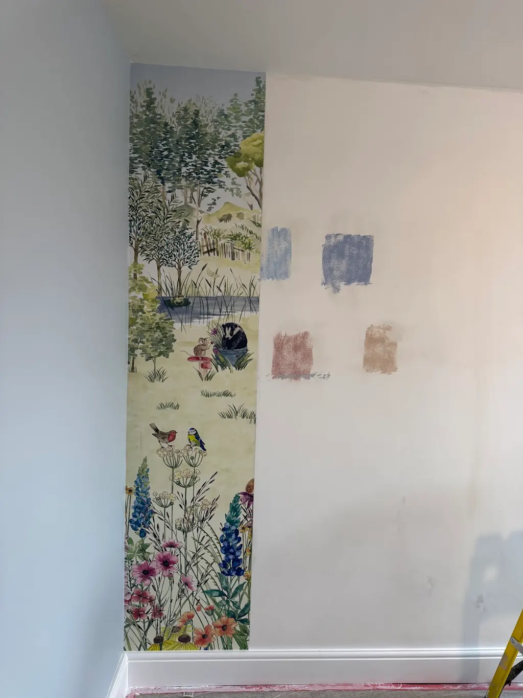 Woodland mural wallpaper installation in progress with paint swatches