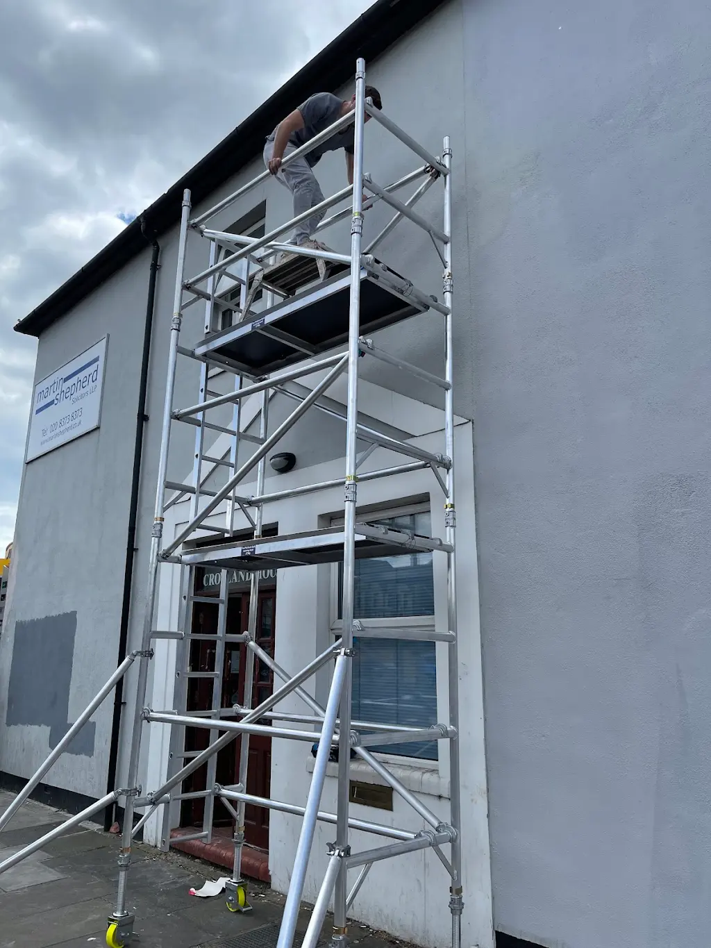 High-level exterior painting from mobile scaffold tower on a commercial property