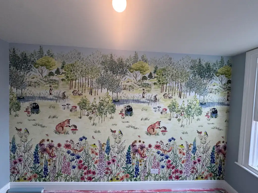 Bespoke woodland mural wallpaper hung across a full bedroom wall