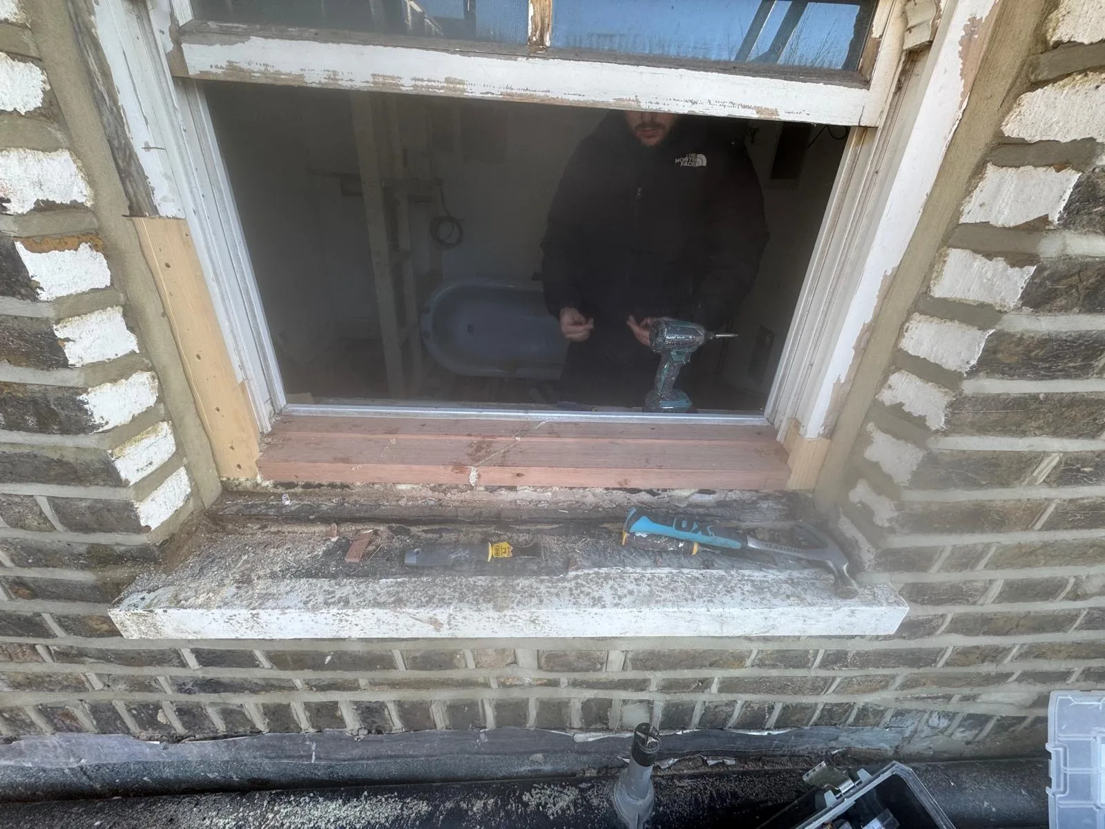 Sash removed and window opening prepped with new hardwood sill during restoration