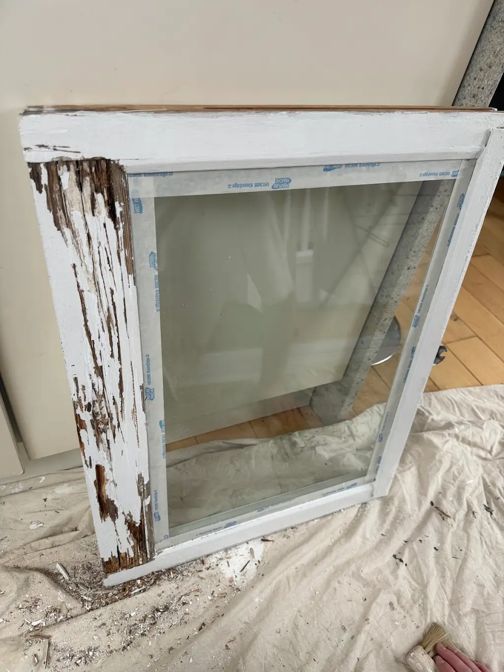 Sash window sash removed for stripping and repair, showing rotted timber