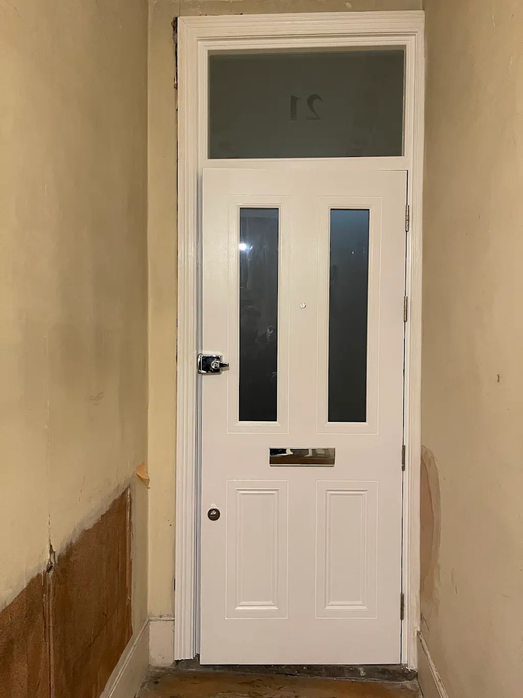 Crisp white internal door and transom repainted in a hallway