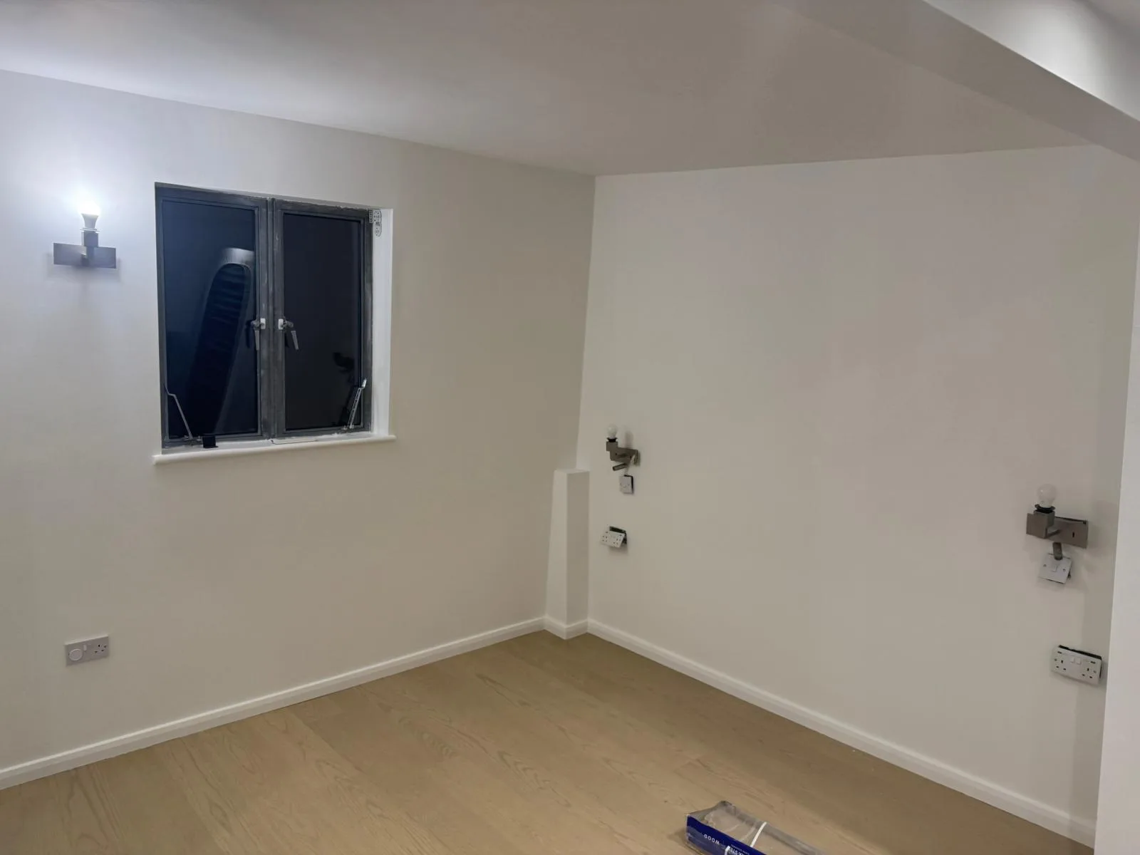 Newly repainted bedroom with soft white walls and clean skirting