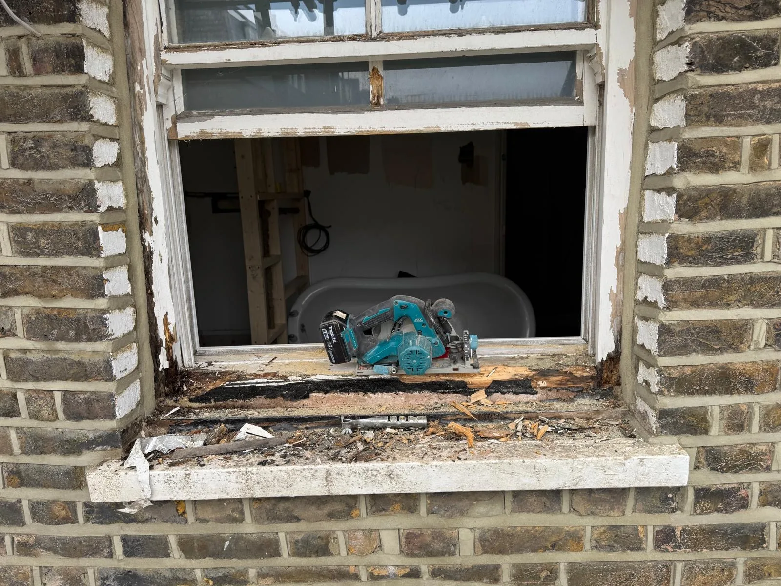 Rotten window sill mid-repair with circular saw and stripped timber