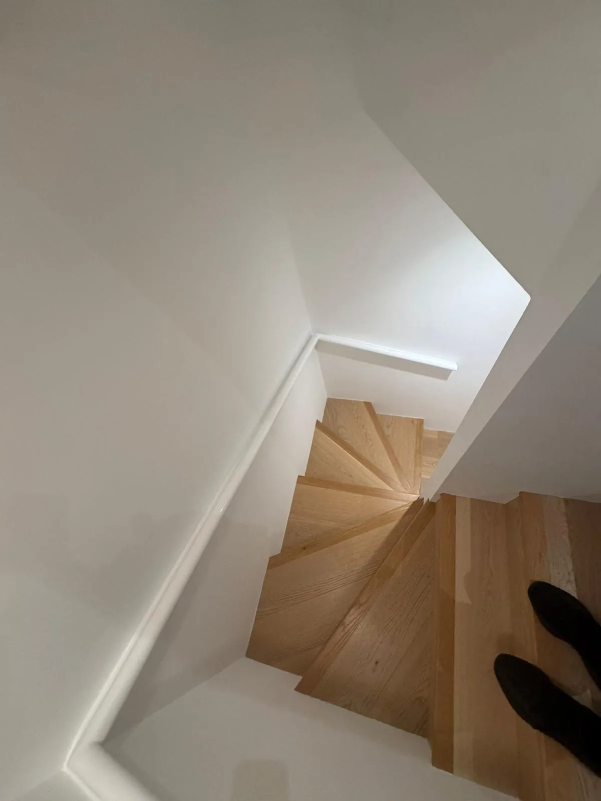 Winder staircase repainted in bright white with oak treads viewed from above