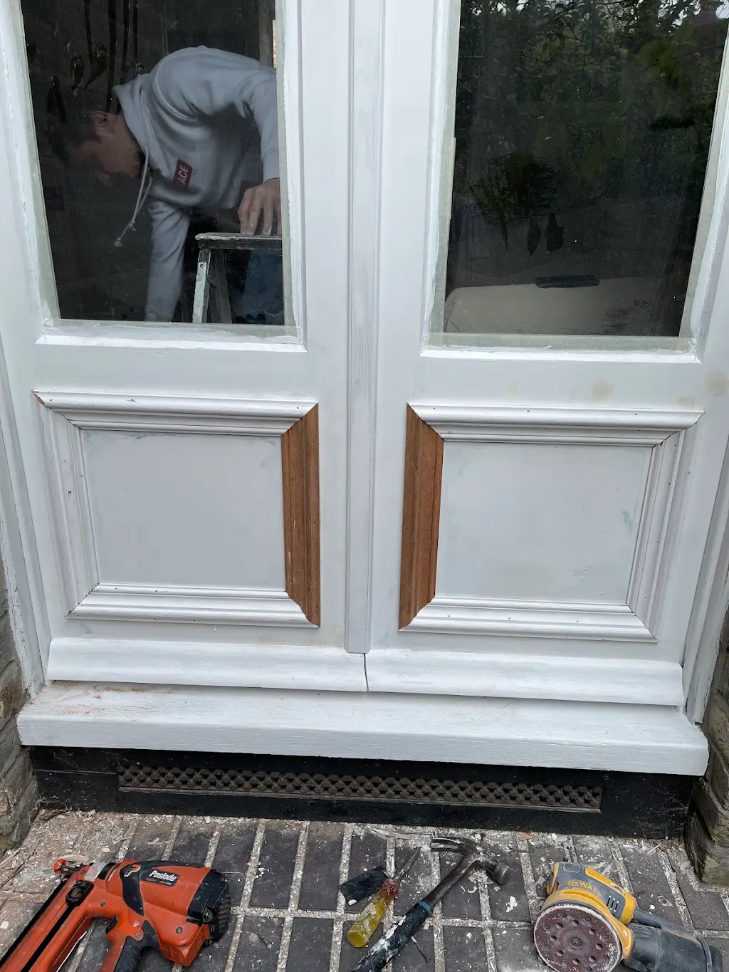 French garden doors with fresh white undercoat during restoration