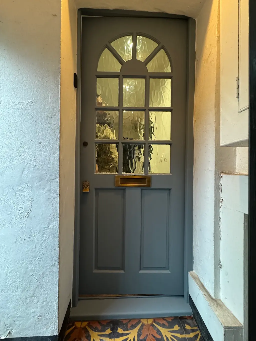 Restored blue-grey Georgian arched front door with brass fittings