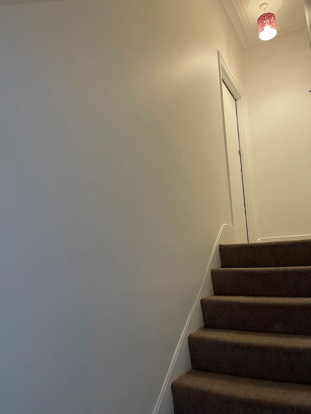 Upper staircase with soft grey walls and crisp white trim
