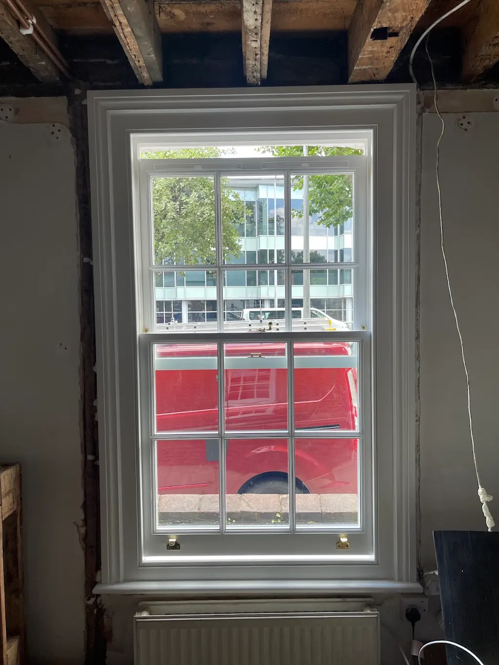 Newly installed sash window with fresh trim mid-renovation