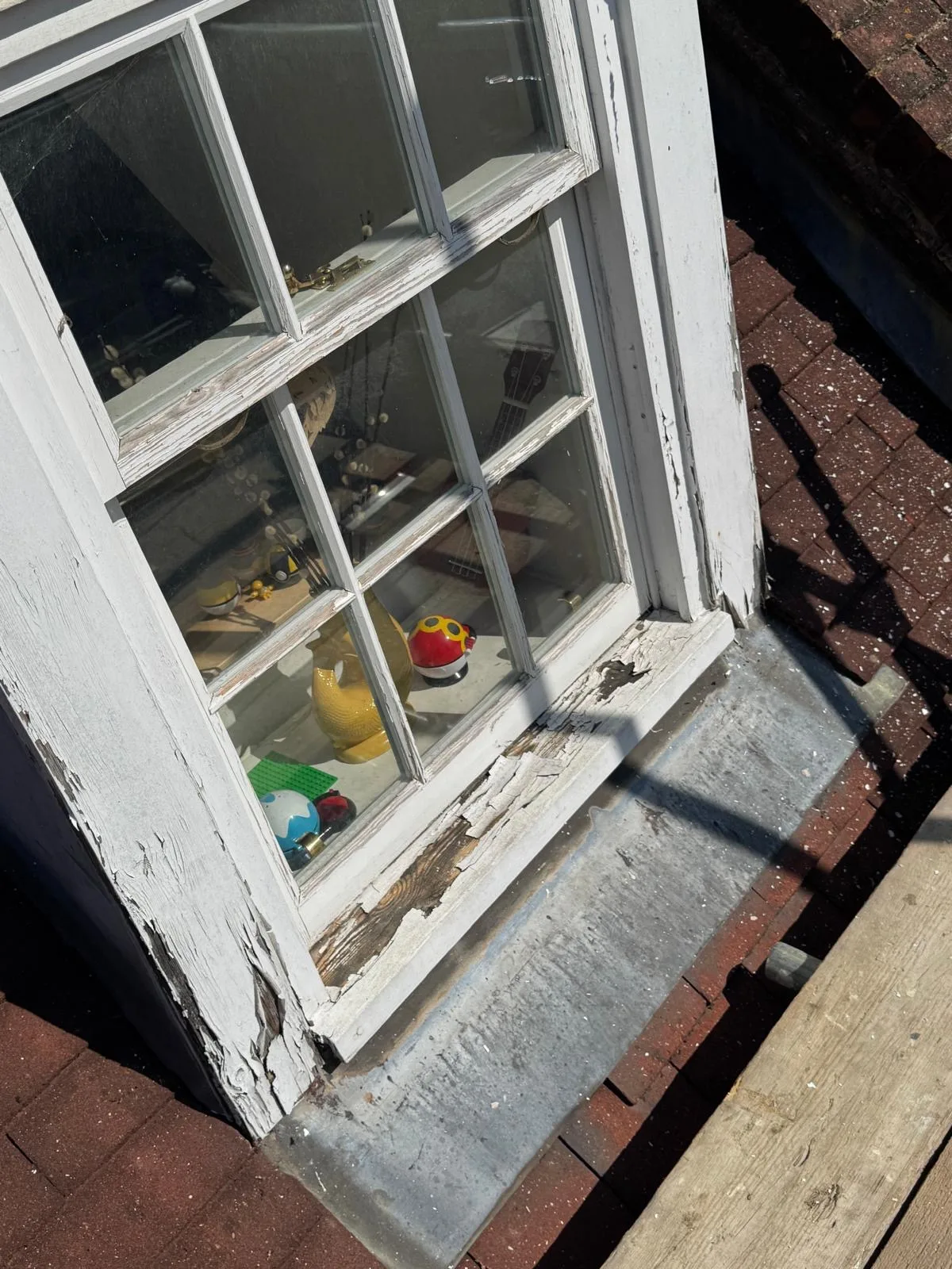 Rotted sash window sill and peeling paintwork awaiting timber repair