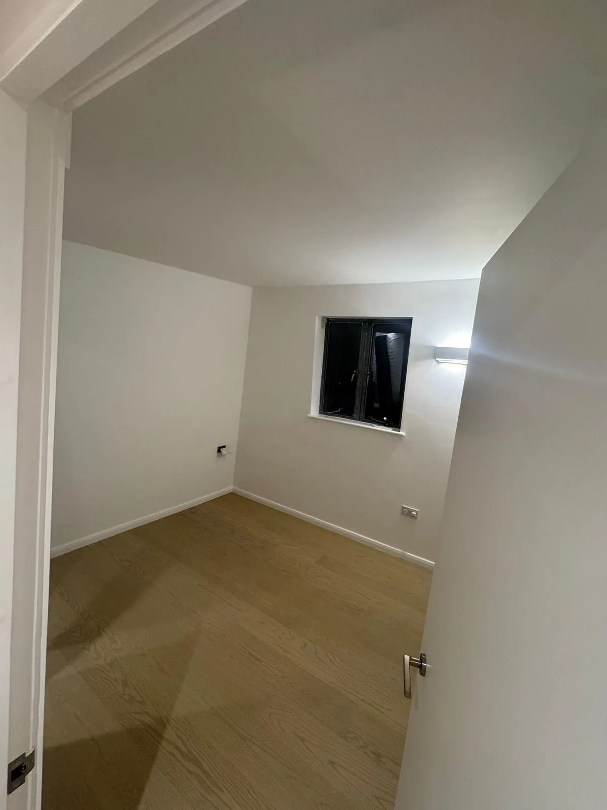 Compact interior room repainted in a clean warm white finish