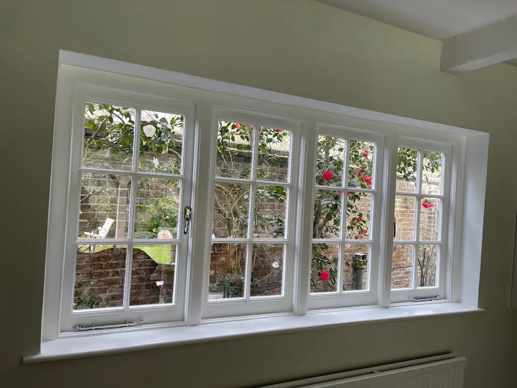 Freshly repainted white cottage casement windows overlooking a garden